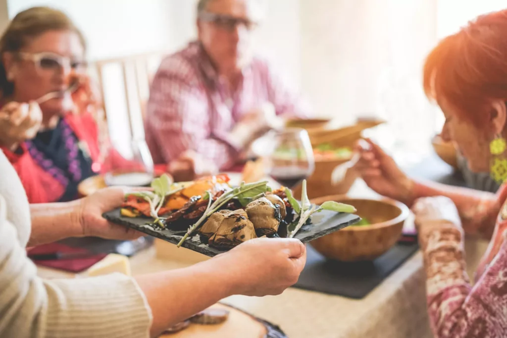 Group of older adults enjoying a healthy meal together in a bright and friendly dining setting.