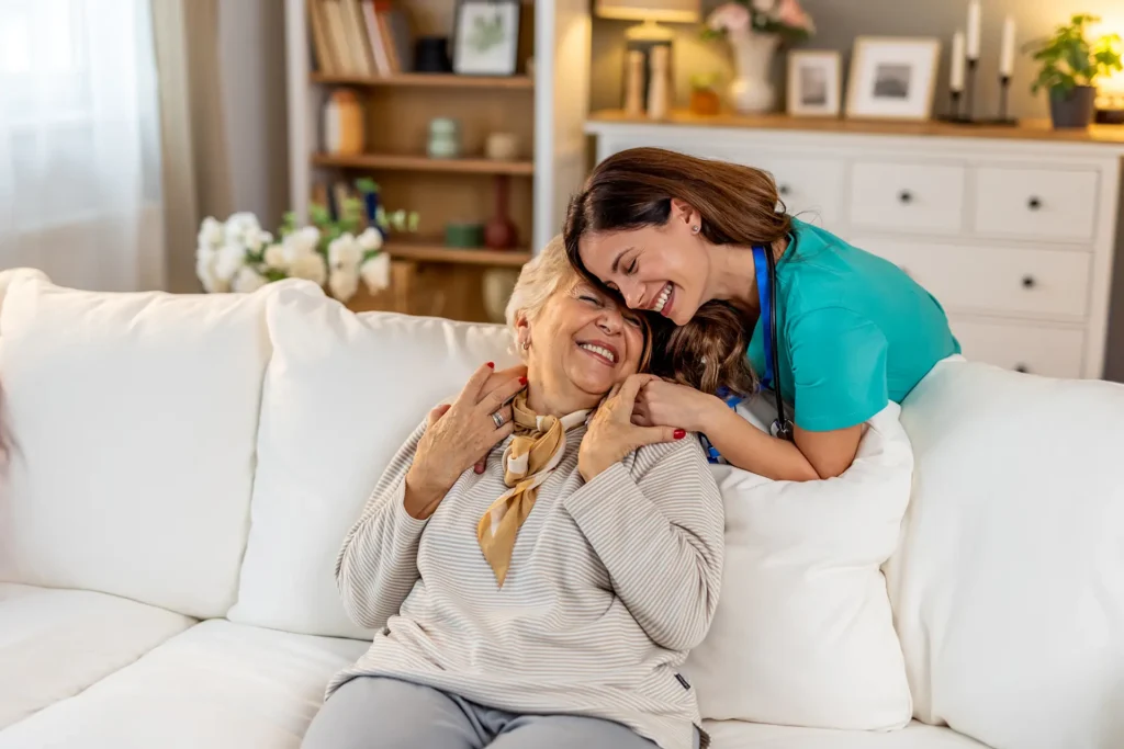 Caring Nurse Comforting a Happy Senior Woman in a Bright Living Room